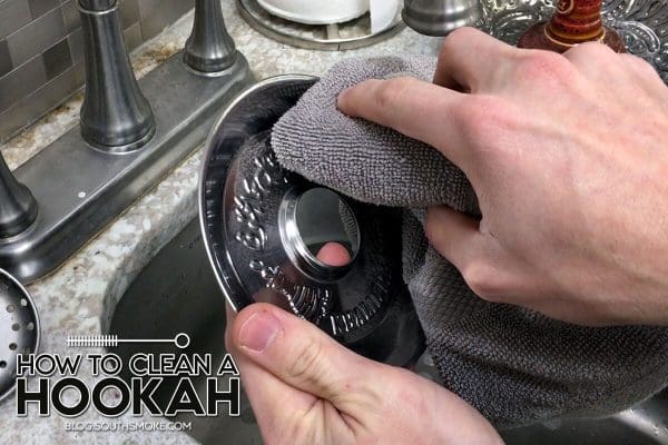 hands cleaning a silver hookah tray with rag at the sink