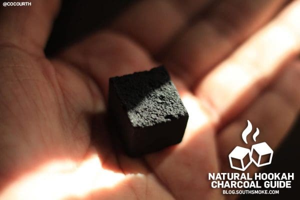Natural Coconut Charcoal Cube in palm of hand