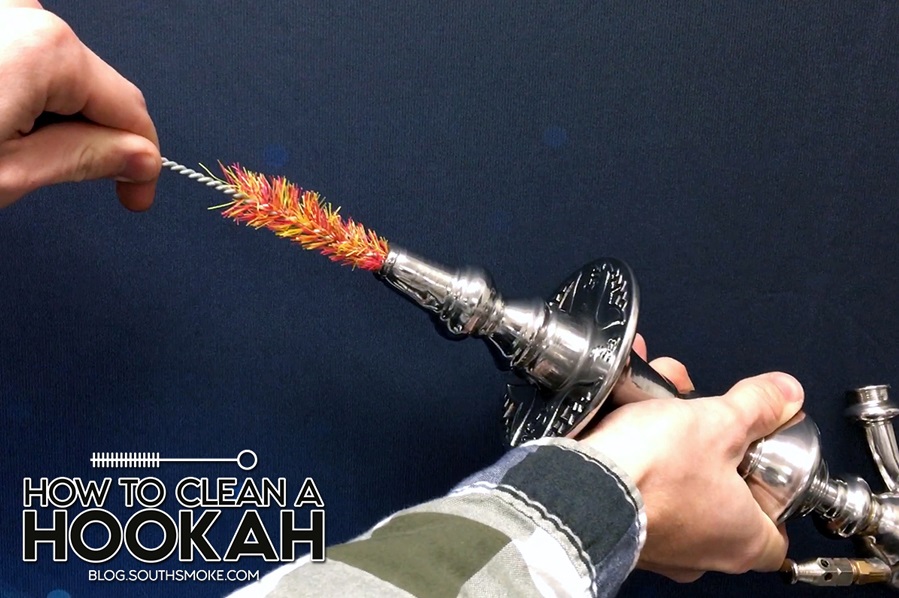 Person cleaning hookah stem with bottle brush