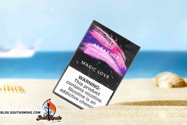 Al fakhers magic love 50g shisha pack on beach with seashells and small boat in background