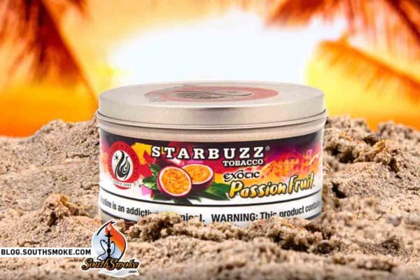 Starbuzz Exotic Passion Fruit Shisha Tobacco Tin on Beach Sand Pile with Sunset in background